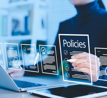 Policy documentation and compliance concept. Businesswoman reviews digital document Policies with icons, checklists, certifications, and financial detail. policy management, regulatory compliance,