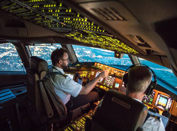 Two pilots at work during departure of Dallas Fort Worth Airport in United States of America. The view from the flight deck with high workload the beginning night through the wind shield